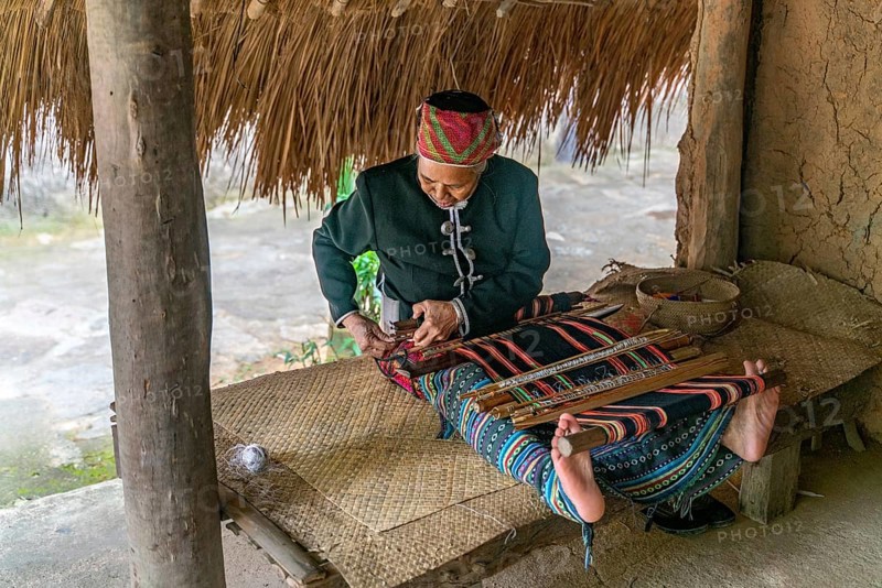 Old woman sew in traditional tribal dress