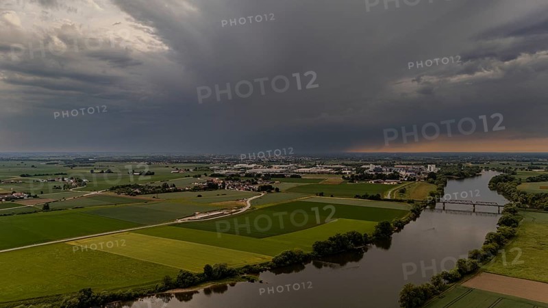 Fields and river stretch out under threatening dark clouds at sunset, Bogen, Lower Bavaria