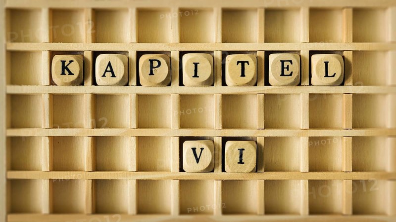 An image of a wooden game with the word chapter six in german language