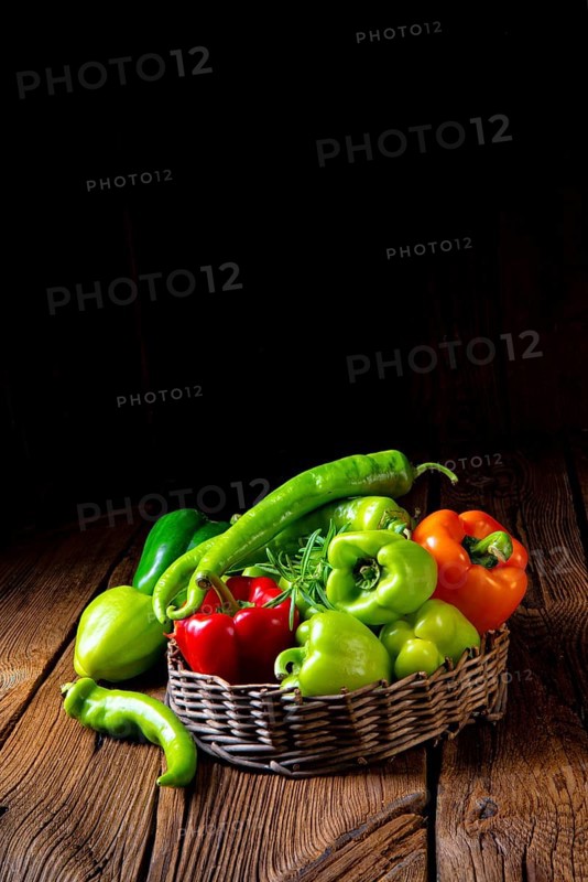 Various harvested peppers and hot peppers in basket