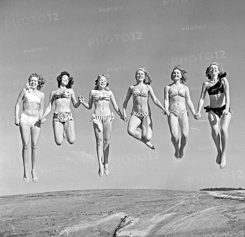 1940s summer. A group of young women in their bikinis are happy on this summer's day, jumping of joy. Sweden 1947. Photo Kristoffersson Ref AD24-5