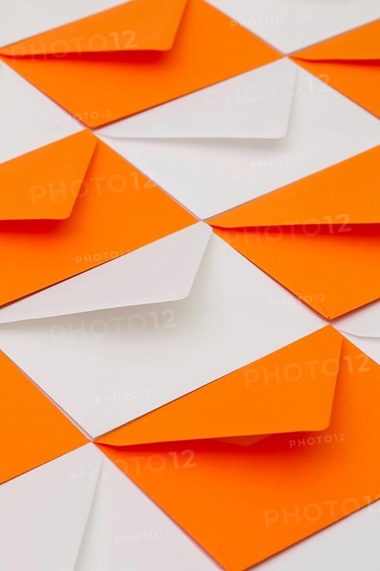 Composition with white and orange envelopes on the table
