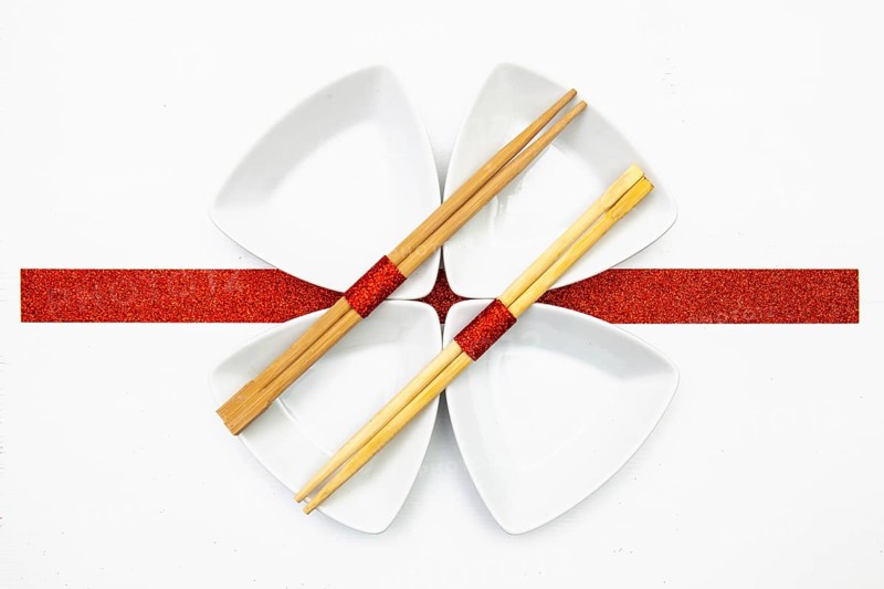 Ceramic bowls and bamboo chopsticks for sushi food with red and white decoration