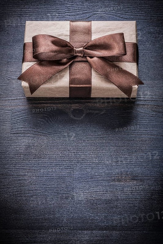 Gift box-container in wrapping paper on vintage wooden board