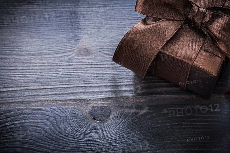 Wrapped present box shining paper on wood board holiday concept