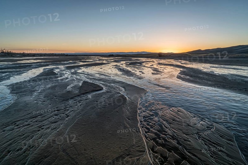 Sunset over shallow Medano Creek disappearing in sand - Great Sand Dunes National Park, Colorado