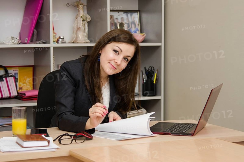 Cute business woman in the office at the computer