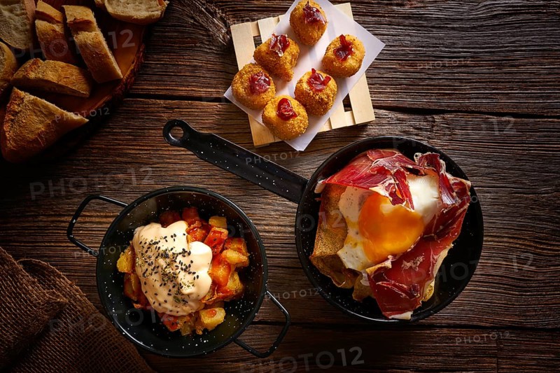 Tapas of Spain broken eggs Croquettes and Bravas potatoes