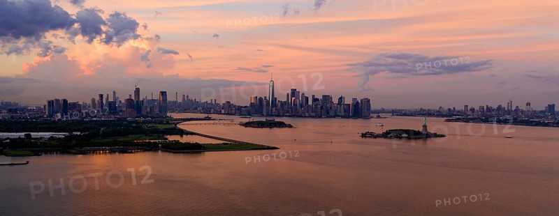 Three cities can be seen in this view of Hudson Bay at dusk with the Statue of Liberty Visable