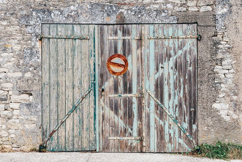 Old wooden closed garage with no parking sign