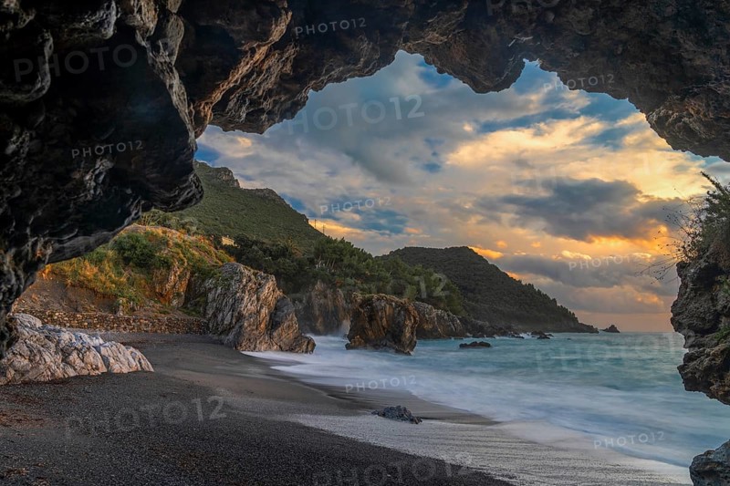 Silhouette frame of a beach cave and view Marina di Maratea Beach at sunset