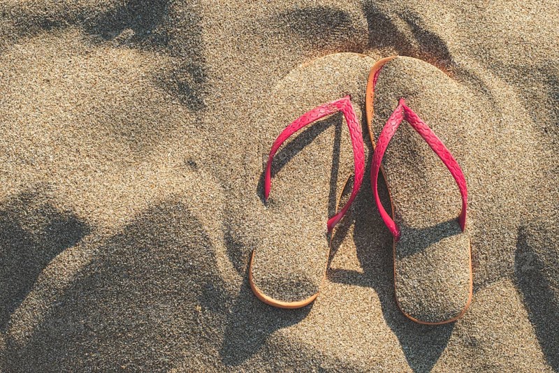 Pink sandals on the beach in the sand