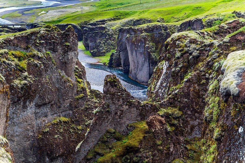 Iceland. The beautiful and mysterious canyon Fyadrarglyufur. Cloudy summer day. River with glacial water flows between bizarre cliffs. The concept of eco, active and photo tourism