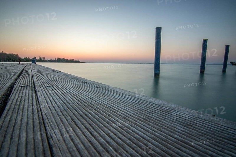 Sunrise on the shore and harbour of a lake in summer. Colourful sky with a wide view of the horiont. Natural landscape at Tihany marina, Lake Balaton, Lake Balaton, Siófok, Hungary, Europe