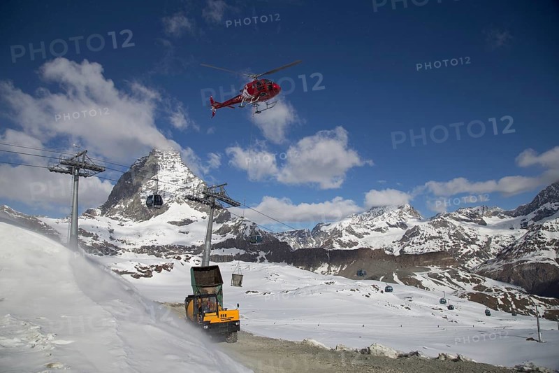 Zermatt, Switzerland, April 13, 2017: A helicopter loading concrete at a construction site in the Swiss mountains, Europe