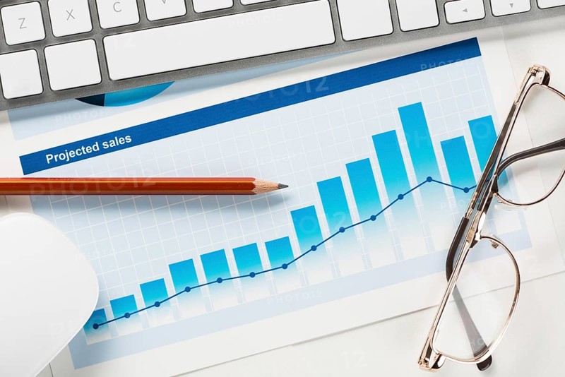 Business workplace with keyboard mouse and papers with graphs and diagrams