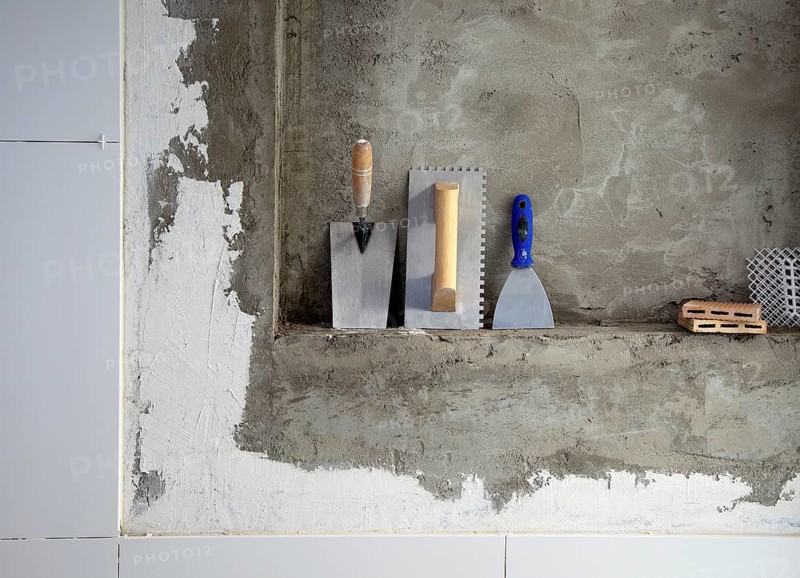 Construction stainless steel trowel tools and spatula on cement mortar wall