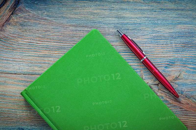 Notepad ball-point pen on wooden board top view education concept