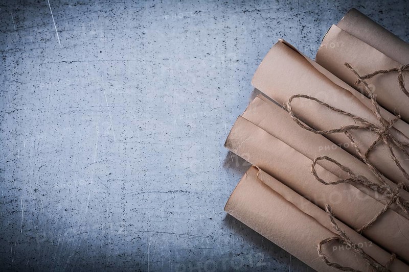 Pile of vintage paper scrolls on scratched metallic background