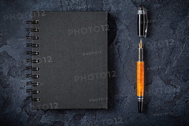 Black Notepad And Fountain Pen On Black Background