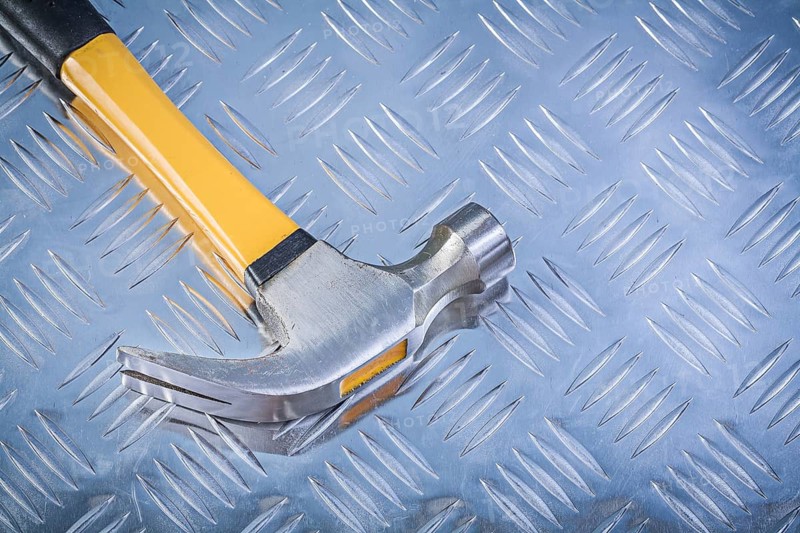 Claw hammer on corrugated metal background construction concept