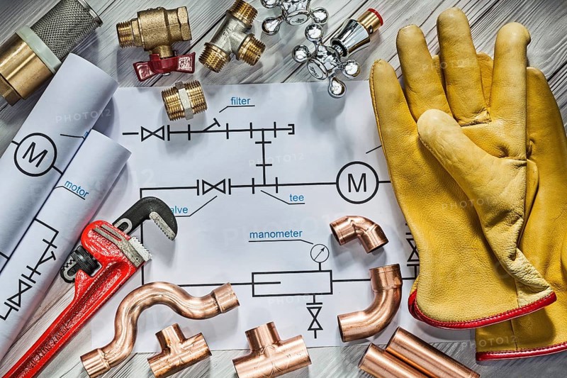 Big set of piping tools on blueprints on vintage white wood