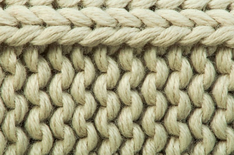 Old knit sweater background. Beige color. Studio shot