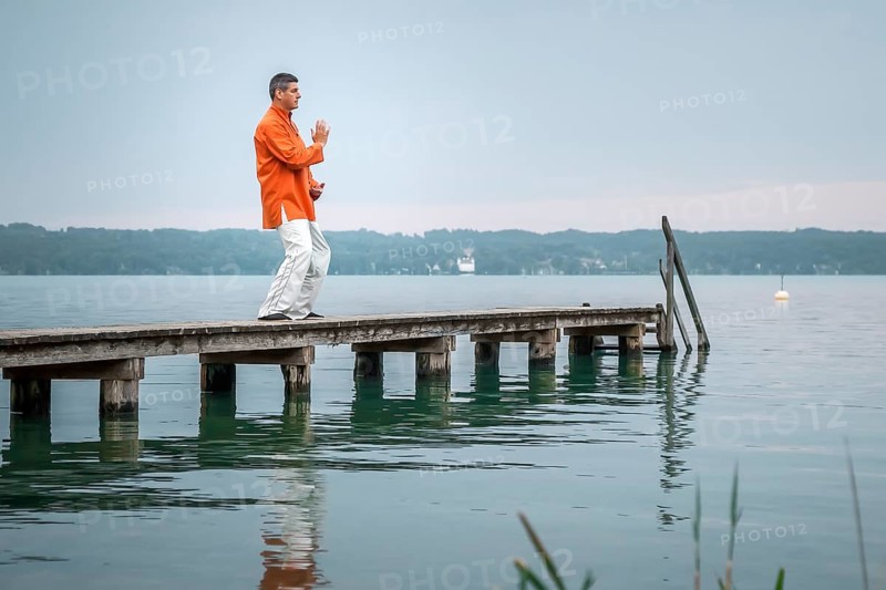 A man doing Qi-Gong in the early morning at the lake Starnberg