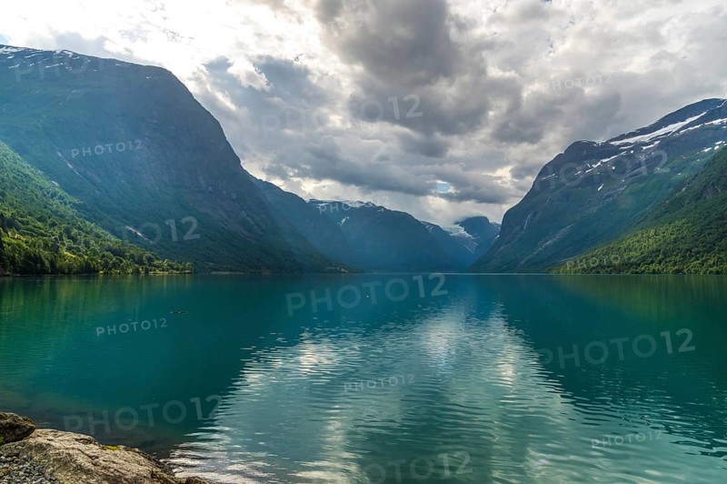 The Kjenndalsbreen is part of the Jostedalsbreen, one of the largest glaciers in Norway, and forms an impressive mountain landscape with a beautiful lake in Sande. The glacier Kjenndalsbreen with a lake in Norway is a beautiful place to travel to in summertime