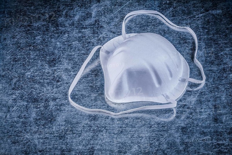 Safety dust mask on metallic background construction concept