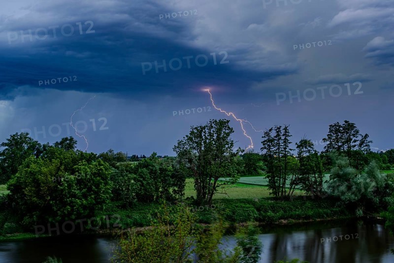 Bright flashes of lightning have illuminated the dark sky over a river, Bogen, Lower Bavaria