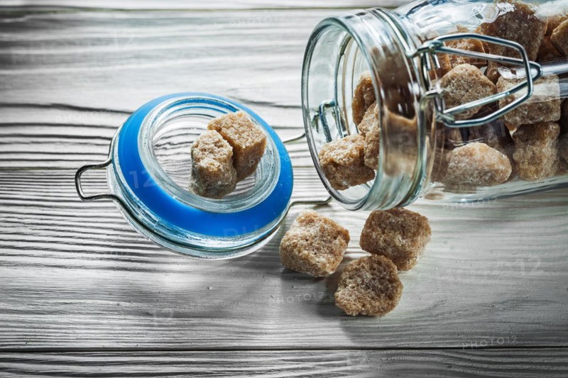 Glass with brown sugar on wooden board