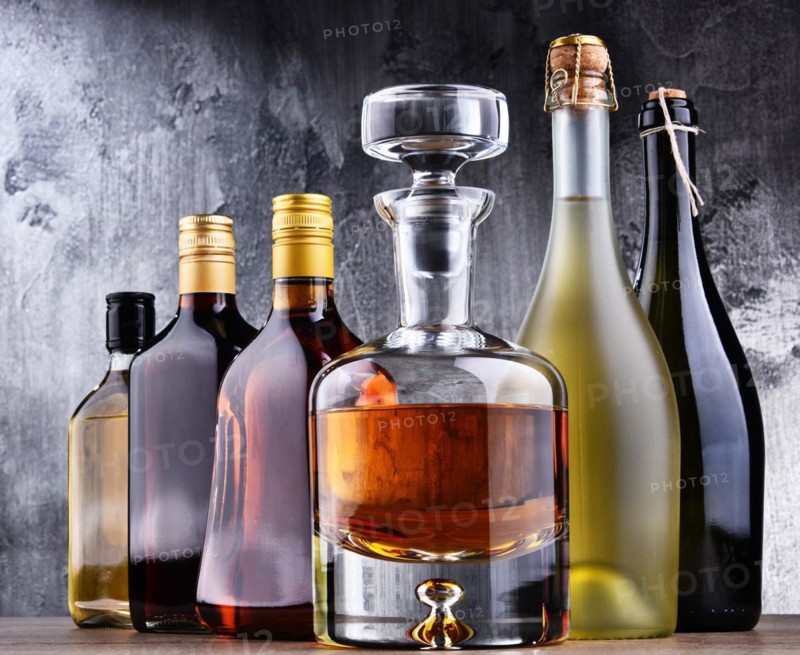 Composition with carafe and bottles of assorted alcoholic beverages