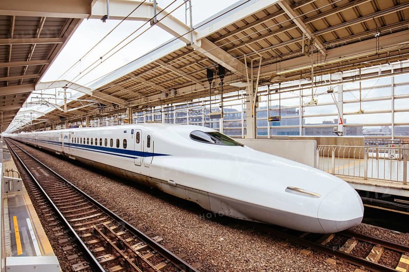 A Shinkansen high-speed bullet train pulling into a train station in Japan