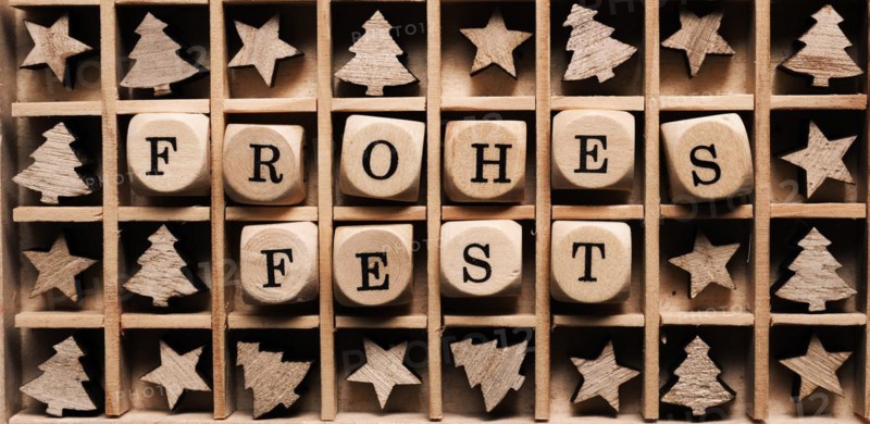 Wooden box with the German words Merry Christmas and small tree and star shapes