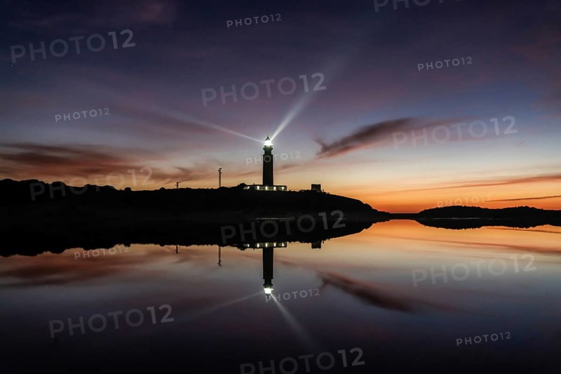 A view of the Cape Trafalgar lighthouse signal light after sunset with colorful evening sky