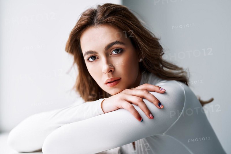 Close up portrait of sensual pretty young woman. Beautiful female model in white cloth with clean skin and sable style eyebrows posing in studio