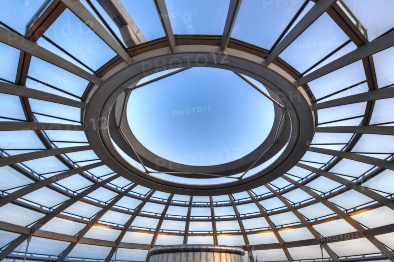 Reichstag in Berlin, the photo shows the dome of the Reichstag with the walkable spiral inside. The architect Norman Foster designed the dome. The glass dome provides the plenum with natural daylight and serves as ventilation. Reichstag building in Berlin. The large glass dome at the very top of the Reichstag has a 360-degree view of the surrounding Berlin cityscape. The main hall of the parliament below can also be seen from inside the dome, and natural light from above radiates down
