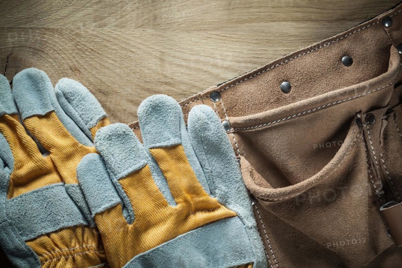 Leather tool belt Safety gloves on wooden board
