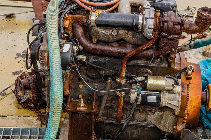 Taean, South Korea. August 14, 2019: Closeup of rusted inboard engine exposed to elements sitting on wet concrete pier