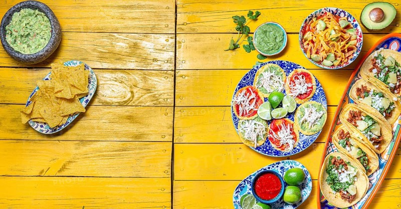 Food, Food, Mexican festive food for independence day, independencia chiles en nogada, tacos al pastor, chalupas pozole, tamales, chicken with mole poblano sauce. Yellow background