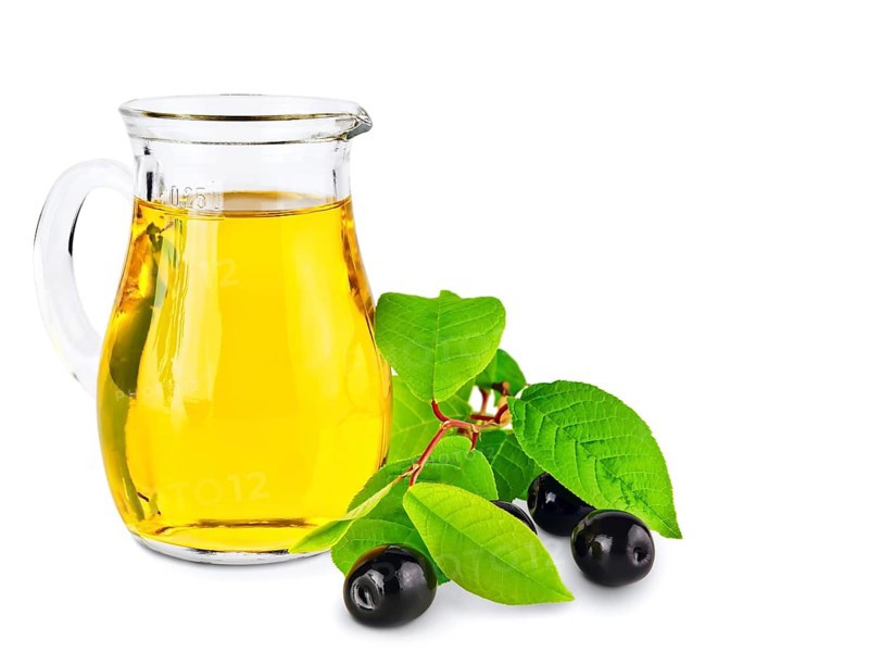 Olive oil and olives wiyh green leaves against white background
