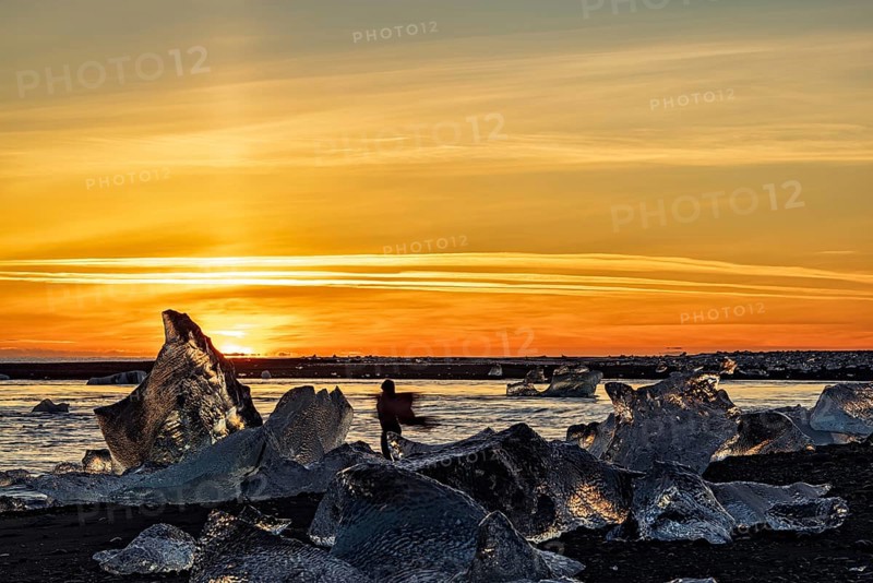 Dancing girl in diamond beach in Vatnajokull National Park at sunset, Iceland, Europe