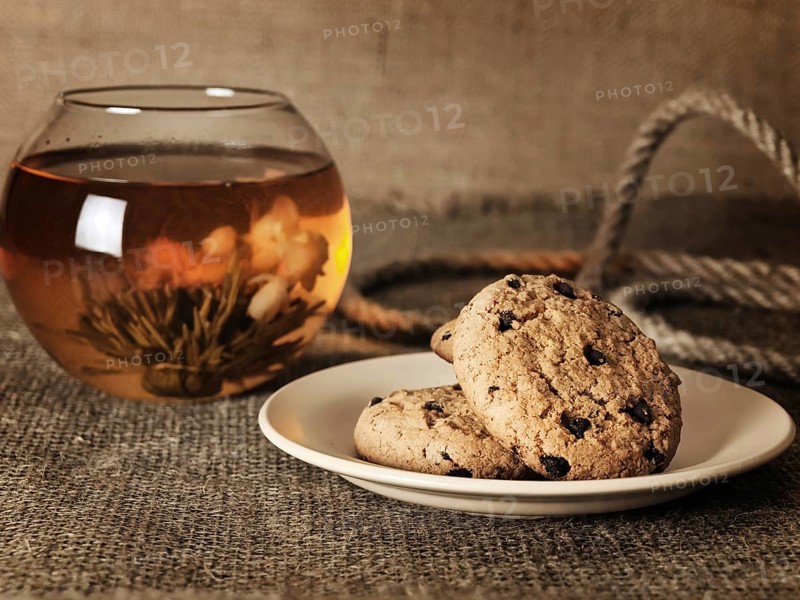 Cookies in front of blossom tea over the burlap background