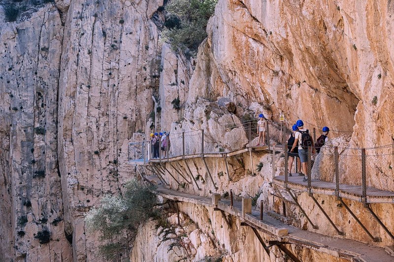 El Chorro, Spain, April 2023: People walking the Caminito Del Rey in the Desfiladero de los Gaitanes, a gorge carved by the Guadalhorce river in the province of Málaga, Spain, Europe