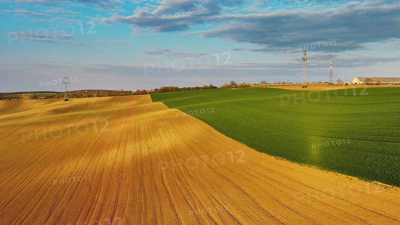 Aerial view of amazing green wavy hills with agricultural fields in evening spring. South Moravia region, Czech Republic, Europe