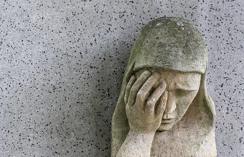 A sad Madonna in the Barbarafriedhof cemetery in Linz, Austria, Europe