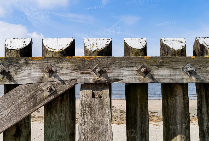The photo shows a solid wooden fence on the island of Baltrum