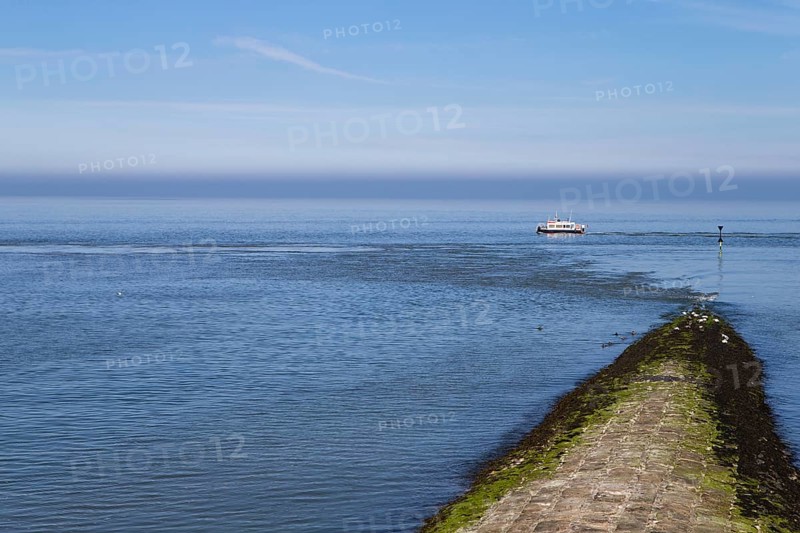 The photo shows a jetty with a survey vessel by day on the island of Baltrum