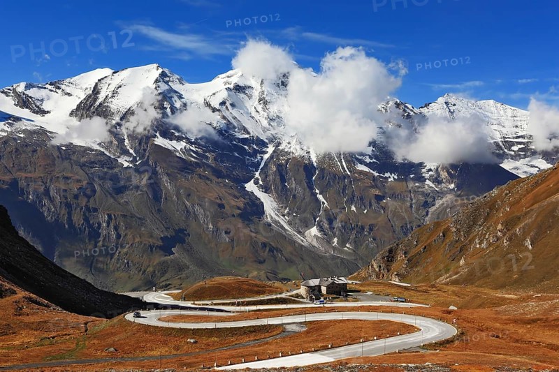 Famous picturesque views of the road in Austrian Alps - Grossglocknershtrasse. Ideal highway winds high in the mountains. The highest mountain peaks covered with fresh snow